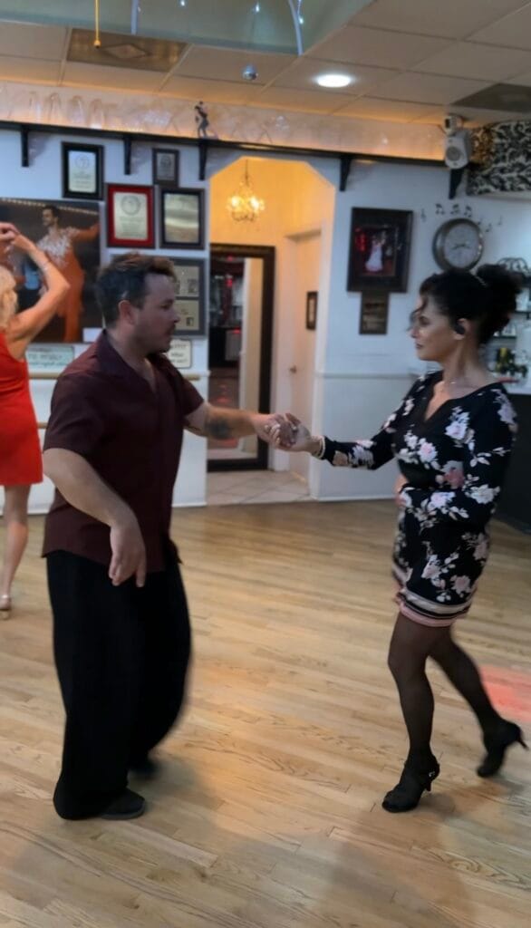 A smiling woman chatting with her instructor in a Sarasota studio, experiencing the benefits of dance for mental health.